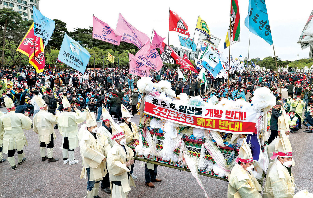 지난 13일 서울 여의도 광장에서 열린 ‘CPTPP 가입 저지를 위한 전국농어민대회’에서 상복을 입은 농어민들이 상여를 메고 행진하고 있다.