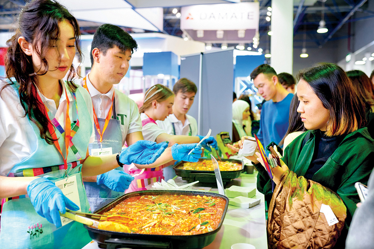 2022년 11월에 열린 카자흐스탄 국제식품박람회 내 한국관에서 현지 소비자들이 떡볶이를 맛볼 준비를 하고 있다. 