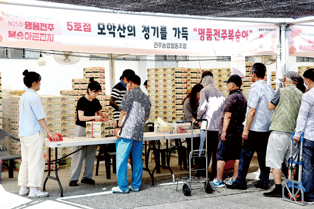 19일 전주종합경기장에서 열린 제25회 명품전주복숭아큰잔치 행사장을 찾은 시민들이 복숭아를 구매하고 있다.