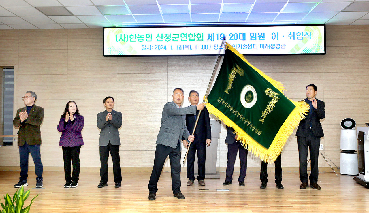 18일 산청군농업기술센터 미래농업관에서 개최된 한국후계농업경영인산청군연합회 제19대, 20대 임원 이·취임식. 유승현 제20대 회장이 회기를 흔들고 있다.