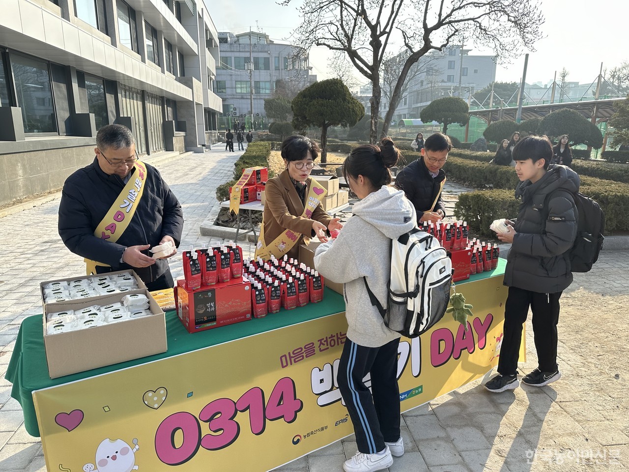 등교하는 춘천중학교 학생들에게 백설기와 음료를 나눠주고 있다.