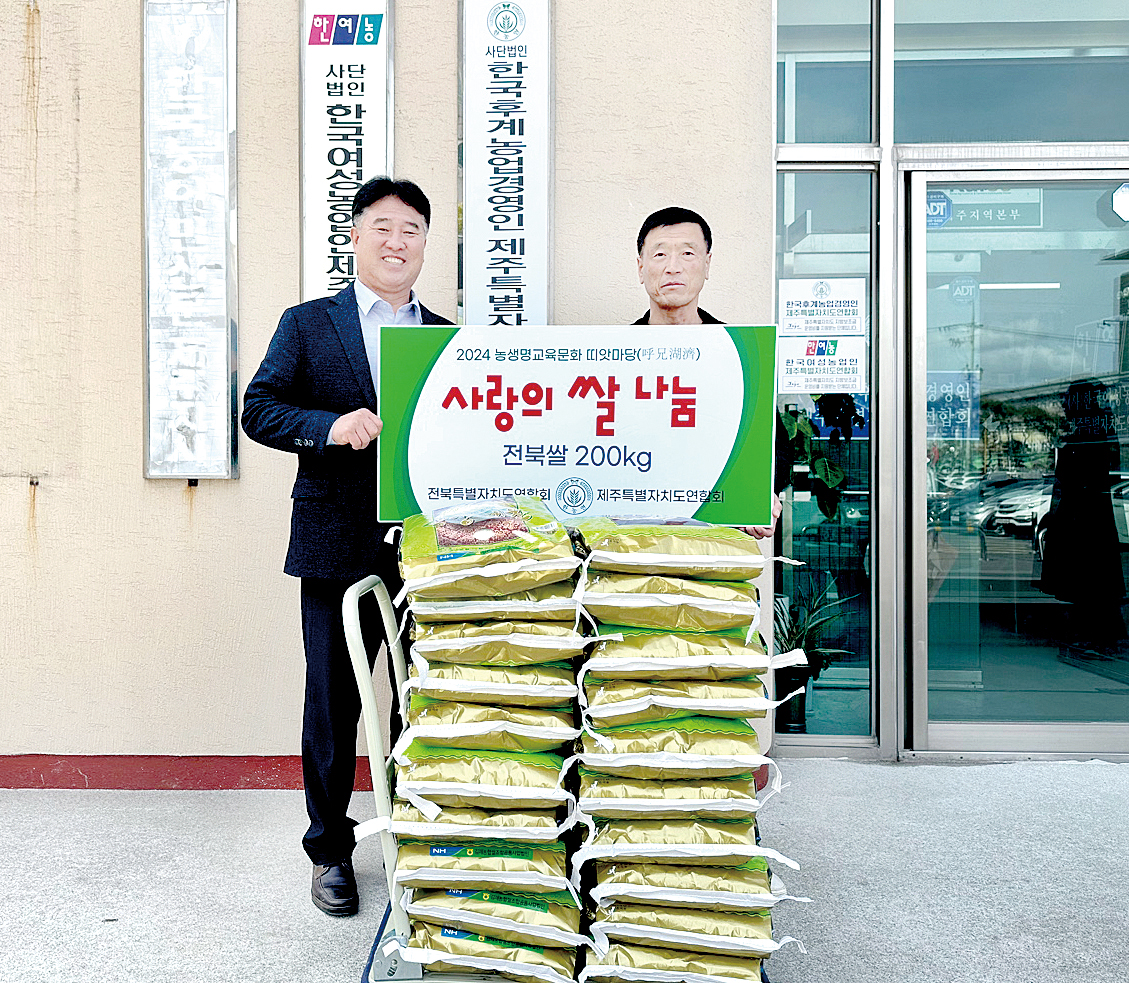이훈구 한농연전북연합회장(오른쪽)이 문병철 한농연제주연합회장(왼쪽)에게 사랑의 쌀 200kg을 전달하고 있다.