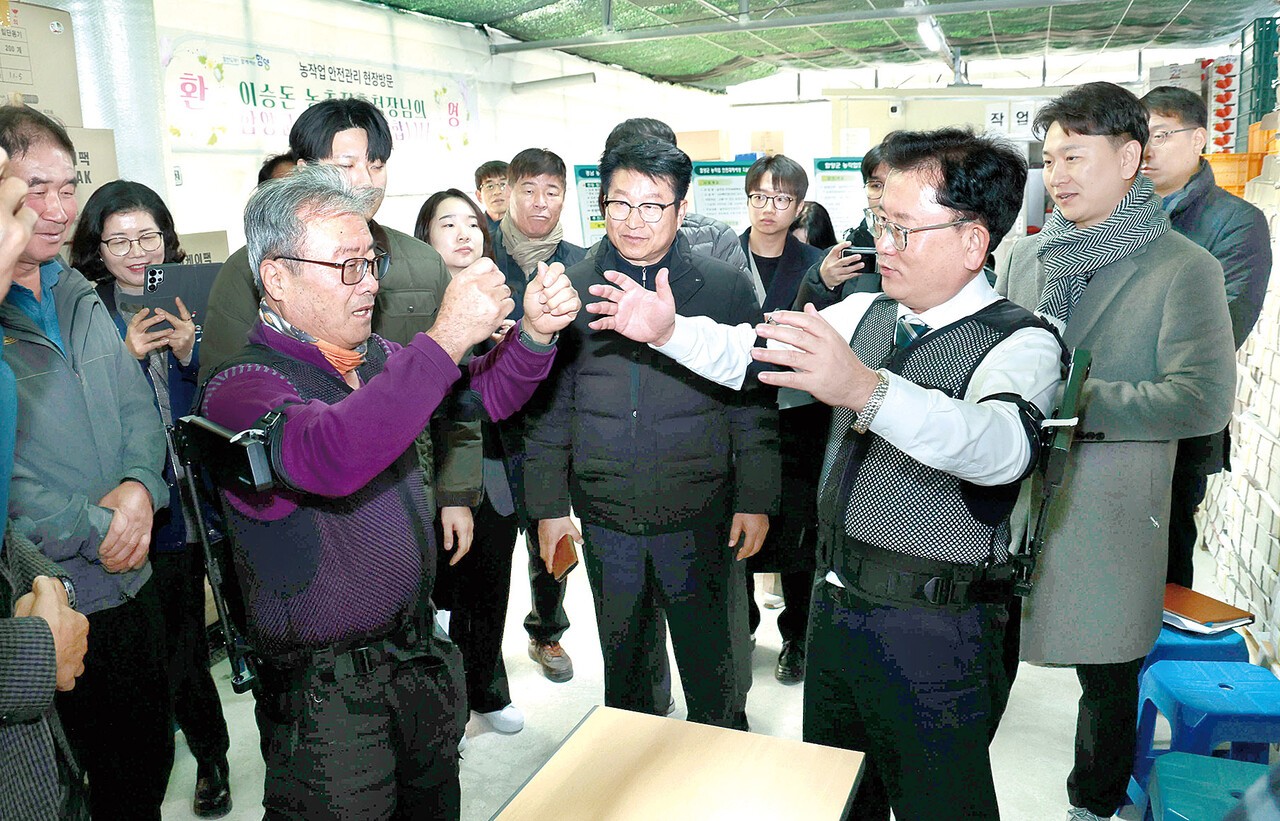 이승돈 농촌진흥청장(사진 오른쪽)이 경남 함양의 시설채소작목반 딸기농장을 방문해 현장의 농업인과 함께 농업용 어깨보조 웨어러블 편이 장비를 시연하고 있다. 사진제공=농촌진흥청