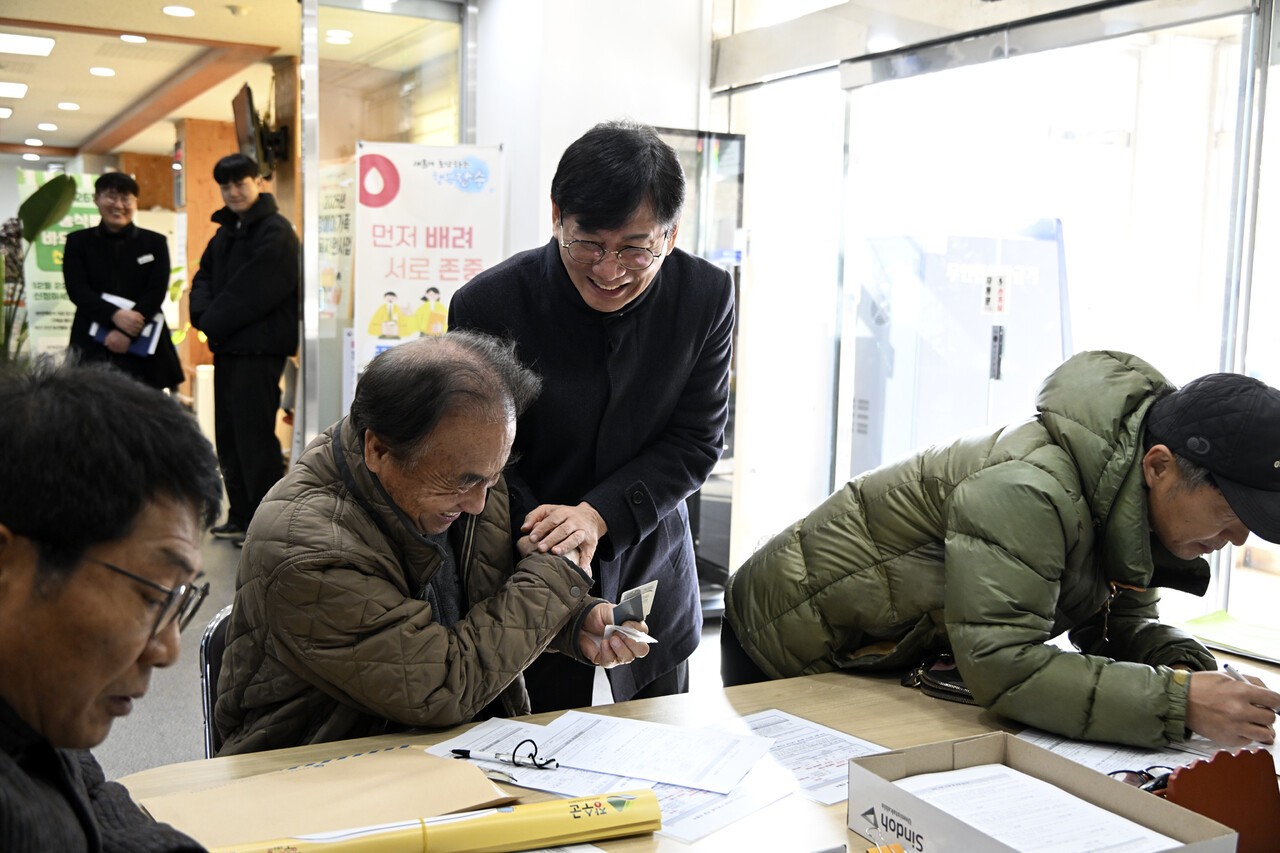 최훈식 장수군수가 농촌기본소득 신청 현장을 찾아 신청 상황을 점검하며 주민들과 악수를 나누고 있다. 사진=장수군
