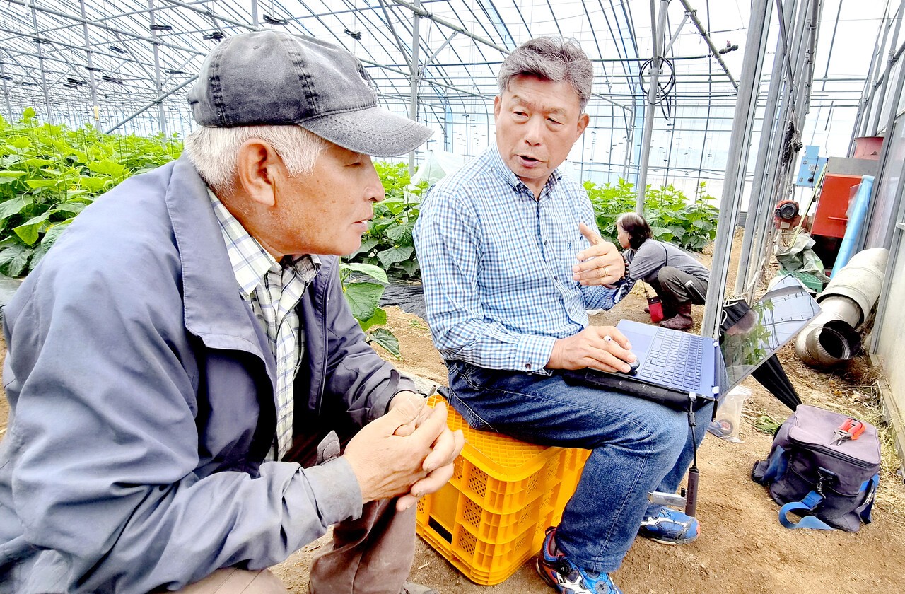 이병오 한바이오 대표(오른쪽)가 정서웅 씨(왼쪽)에게 농장의 토양분석 결과와 여과 액비 사용량을 설명하고 있다.&nbsp;