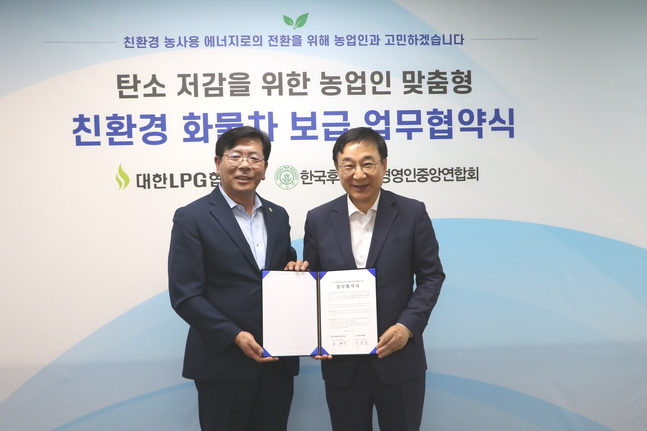 지난 19일 열린 업무협약에서 최흥식 회장(사진 왼쪽)과 이동진 회장이 업무협약서를 들어 보이고 있다.